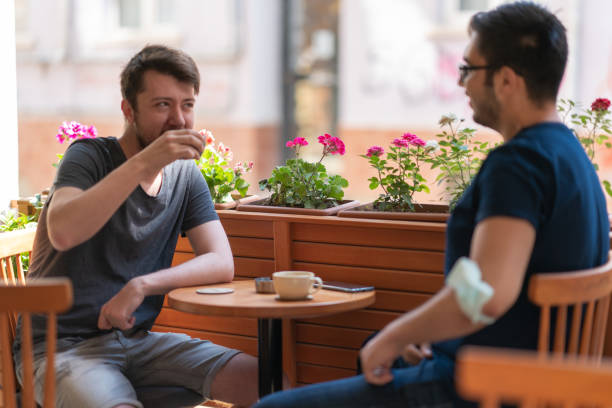 Two Smiling Friends Drinking Coffee and talking in a Cafe