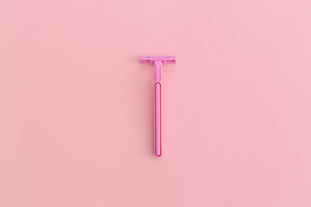 Woman pink plastic razor on pink background. Top view with copy space. Flat lay composition.