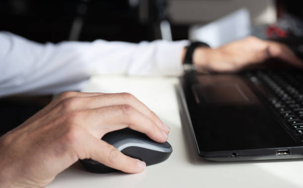 istock Close-up of a man's hands working with a laptop and a mouse 1327527716