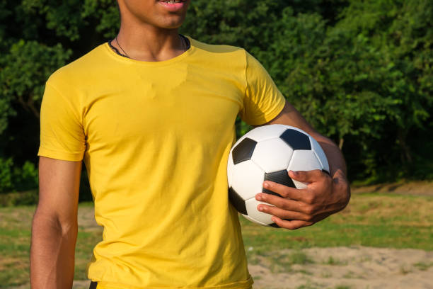 istock African-American man holding soccer ball while standing outdoors in park 1327530295