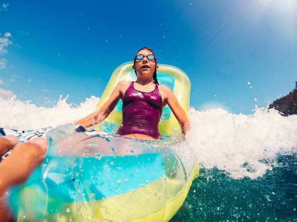 fille flottant sur un lit d’air gonflable dans la mer - child nautical vessel summer swimming goggles photos et images de collection