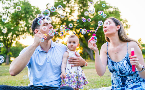 istock Young family blowing bubbles outdoors 1327532512