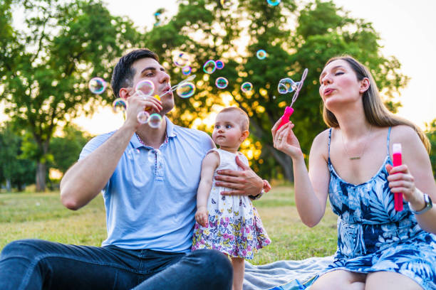 istock Young family blowing bubbles outdoors 1327532719