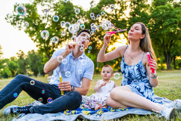 istock Young family blowing bubbles outdoors 1327532772