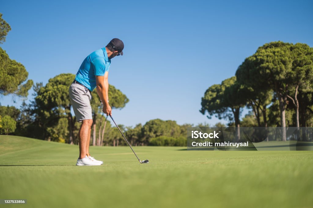 Playing Golf Man playing golf on field. Golf Stock Photo