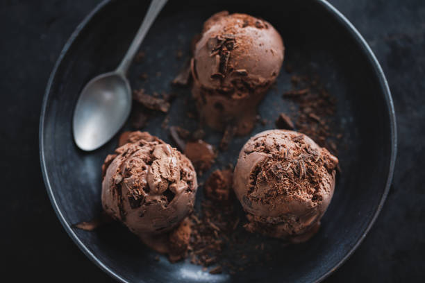 istock Tasty appetizing chocolate ice cream with chocolate chunks on dark plate on dark background. 1327536014