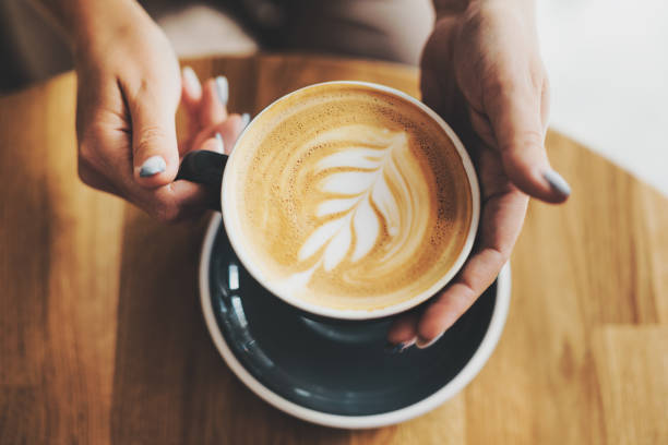 istock Tasty cappuccino in cup on wooden table 1327536035