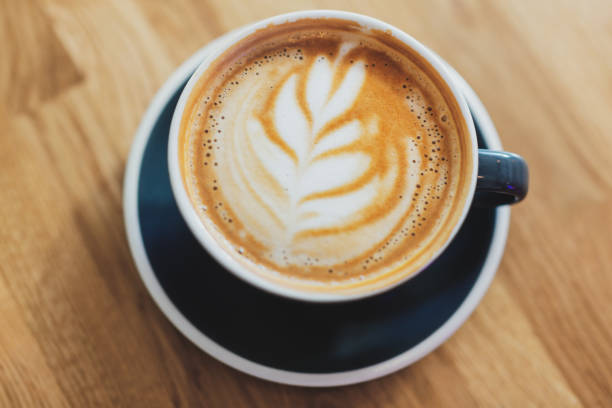 istock Tasty cappuccino in cup on wooden table 1327536647