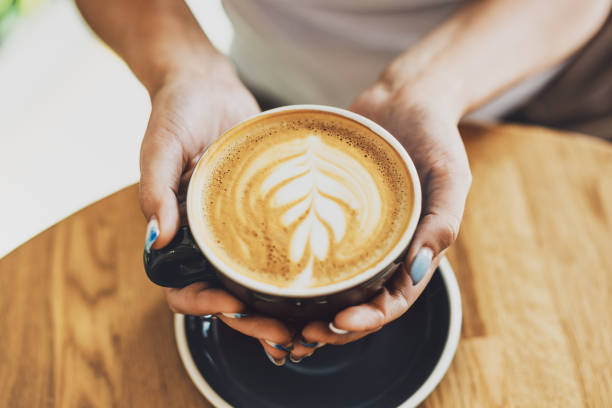 istock Tasty cappuccino in cup on wooden table 1327536685