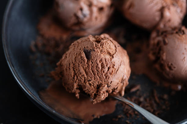 istock Tasty appetizing chocolate ice cream with chocolate chunks on dark plate on dark background. 1327536816