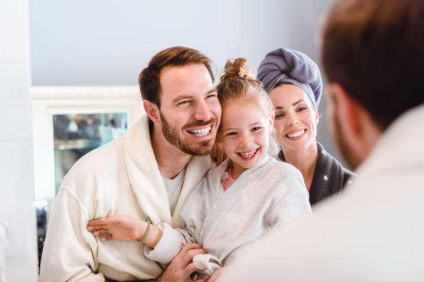 schöne lächelnde glückliche familie im badezimmer, nachtroutine - mirror mother bathroom daughter stock-fotos und bilder