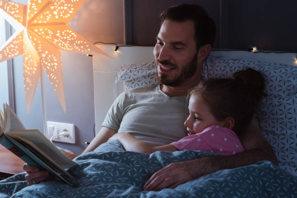 istock Father reading a book for a child in bed before sleep 1327538088
