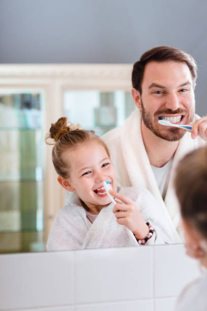 istock Father and daughter brushing teeth 1327538673