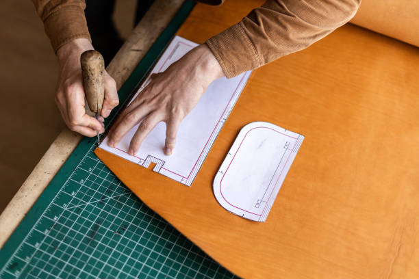 istock Male tanner making cutting scheme of bag working at leather workshop. Handcrafted creating 1327540621