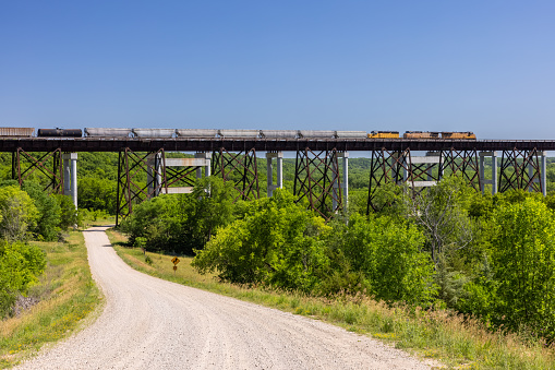 A freight train crossing a high trestle bridge.