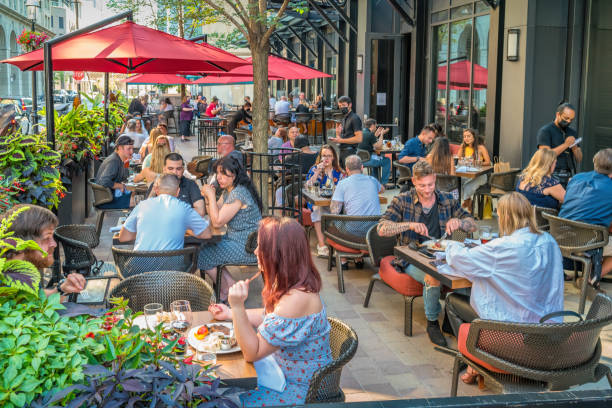 People dining restaurant patio Downtown Toronto Canada People dine on a restaurant patio in downtown Toronto Ontario Canada on a sunny evening. outdoor dining photos stock pictures, royalty-free photos & images