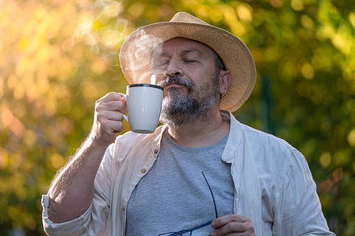 Senior Man Drinking a Coffee or a Tea Outdoors.