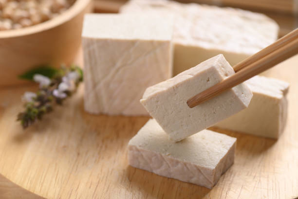 Fresh Tofu eating by chopsticks on wooden cutting board stock photo