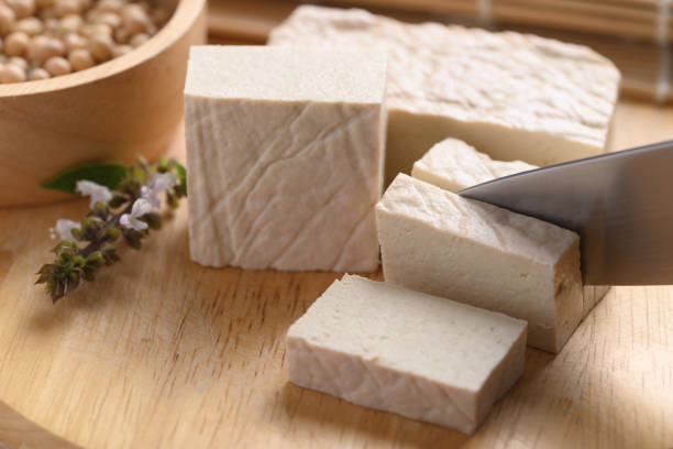 istock Fresh Tofu cutting by kitchen knife on wooden board 1327543721