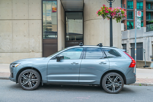 A Volvo XC60 SUV is parked on the street in downtown Toronto Ontario Canada on a cloudy day.