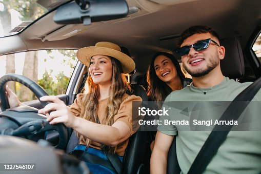istock happy friends traveling by car 1327546107
