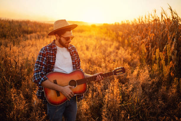 istock One handsome man playing guitar outdoors during the sunset 1327551424