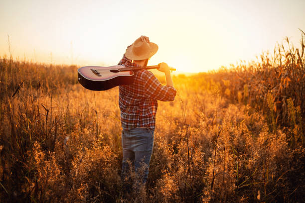 istock Unrecognizable young man with guitar walking on the field 1327551426