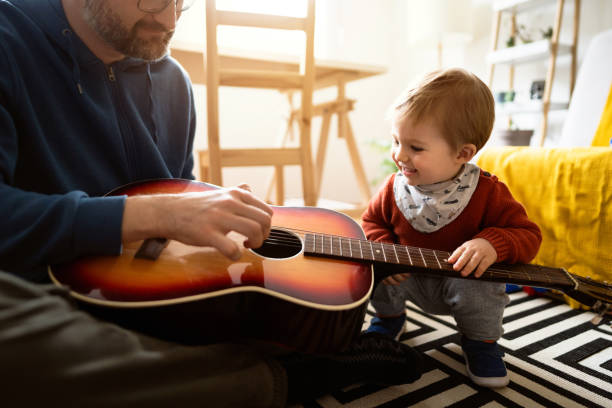 istock Unrecognizable father playing guitar with his little son 1327552046