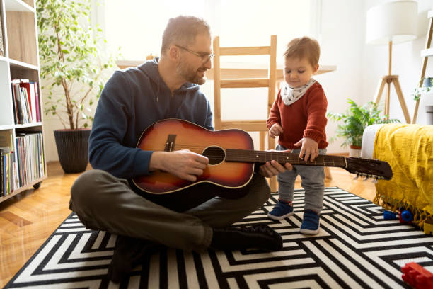 istock Father and son playing guitar together at home 1327552056