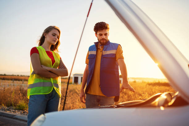 istock Road assistance man helping a young woman with broken car 1327552195