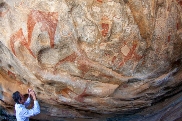 The Ancient Rock Paintings of Laas Geel Laas Geel, Somaliland, Somalia - Jan 24, 2014: A man holding a camera and looking up at ancient rock paintings hargeysa photos stock pictures, royalty-free photos & images