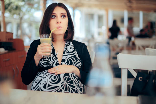 istock Pregnant Woman Drinking Lemonade in a Restaurant 1327557715