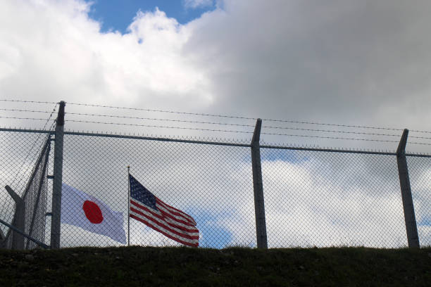 bandera japonesa y bandera estrellada vista a través de la valla - star spangled banner fotografías e imágenes de stock