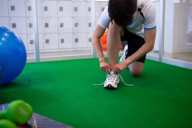 istock Athletes men tying sneaker shoelaces. 1327564597