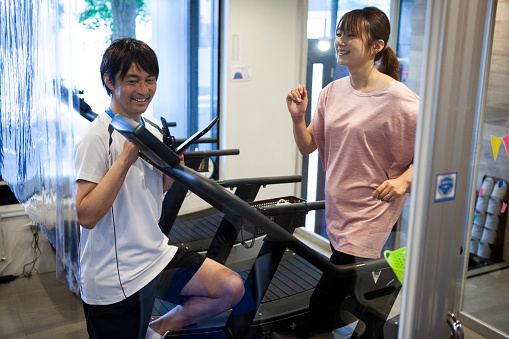 Japanese woman who enjoys sports.\nSports trainer is teaching her.