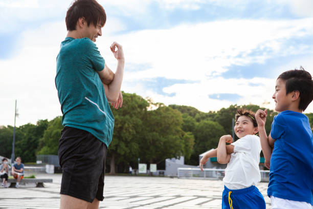 entrenadores y jugadores de fútbol para niños que se estiran antes del entrenamiento. - soccer child coach childhood fotografías e imágenes de stock