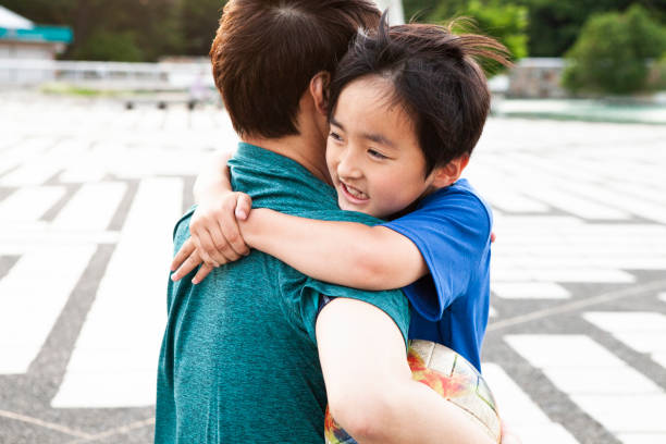 istock Soccer player father and son are hugging. 1327567952