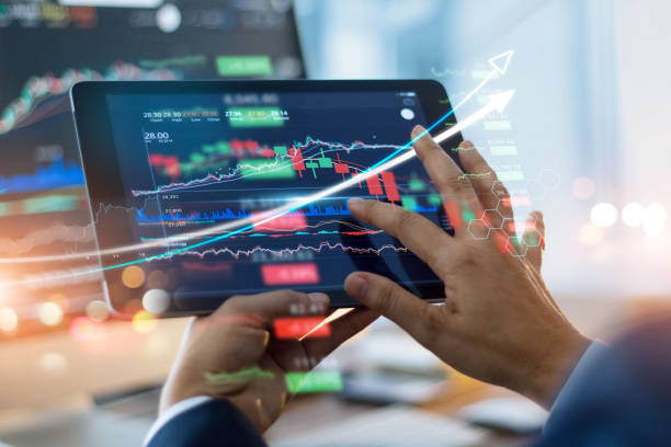 istock Businessman using tablet and showing a growing virtual hologram of statistics, graph and chart with arrow up on dark background. Stock market. Business growth, planing and strategy concept. 1327568762