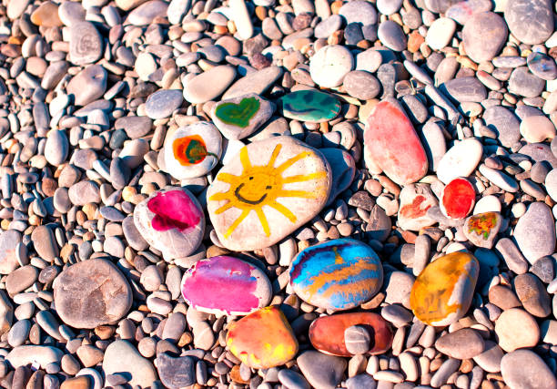 istock Multicolored children's drawings on stones by the sea 1327570501