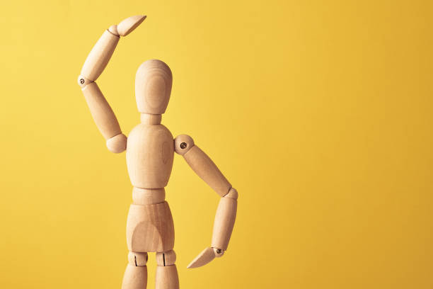 istock Wooden doll on yellow background 1327571367