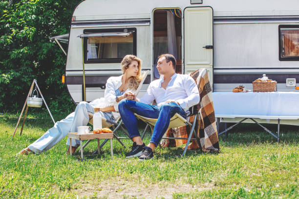 couple of a beautiful woman in love and a man in nature are relaxing traveling in a trailer, a mobile home - semi skimmed milk imagens e fotografias de stock