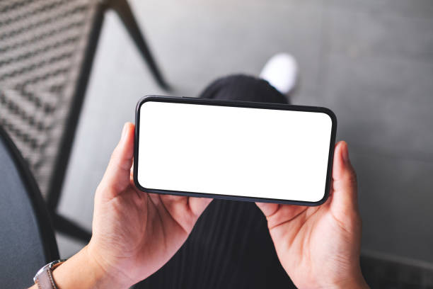 istock a woman holding mobile phone with blank white desktop screen 1327582456