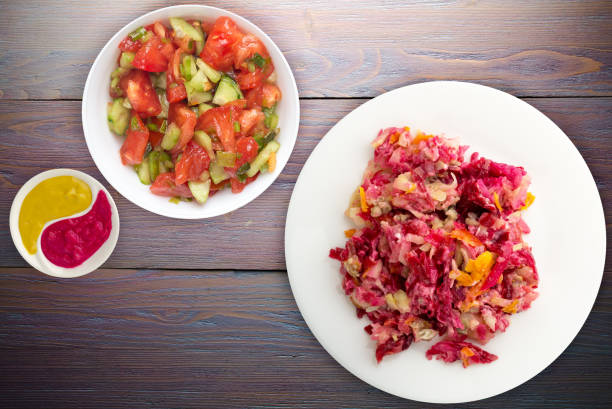 istock herring under a fur coat on a white plate. Herring under a fur coat on a wooden background. herring, beetroot, carrot, mayonnaise and onion salad . 1327583132