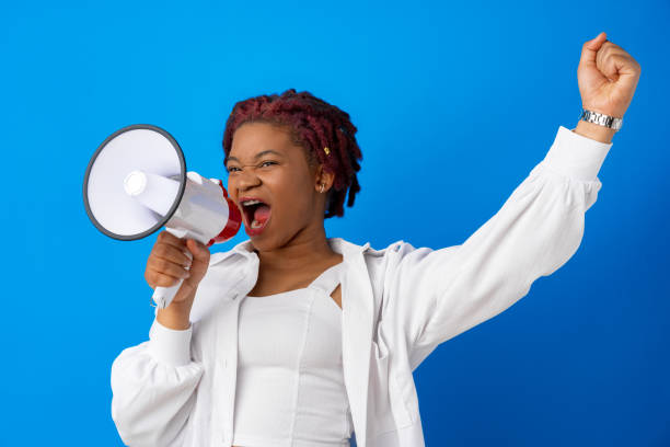 istock African american woman using megaphone against blue background 1327584282