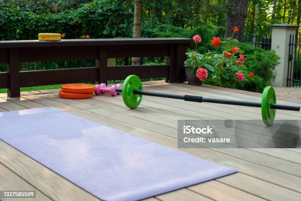 Home Training Equipment On Home Yard Terrace Yoga Mat And Weighs Fitness At Home Stock Photo - Download Image Now
