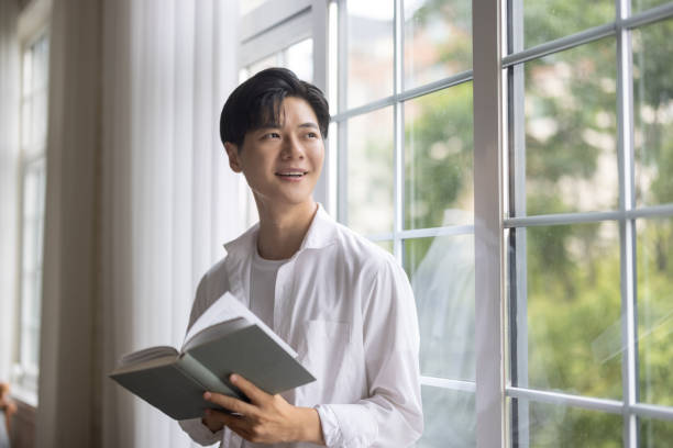 istock Asian man reading in a coffee shop 1327585718