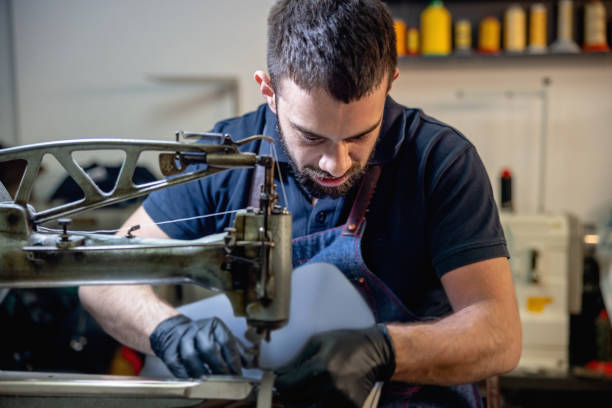 istock Young craftsman fixing women's purse on sewing machine 1327585823