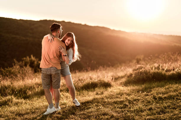 istock Cheerful couple having fun in spring day at sunset. 1327586821