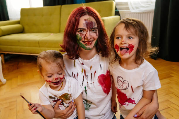 istock Family hobbies leisure activity home concept. Mother and small daughter drawing with fun using paintbrushes and watercolors. Children and parent creating picture together, body paint, home quarantine. 1327586854