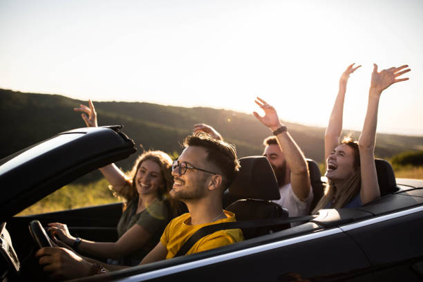 istock Young happy couples going on a road trip by convertible car. 1327586961